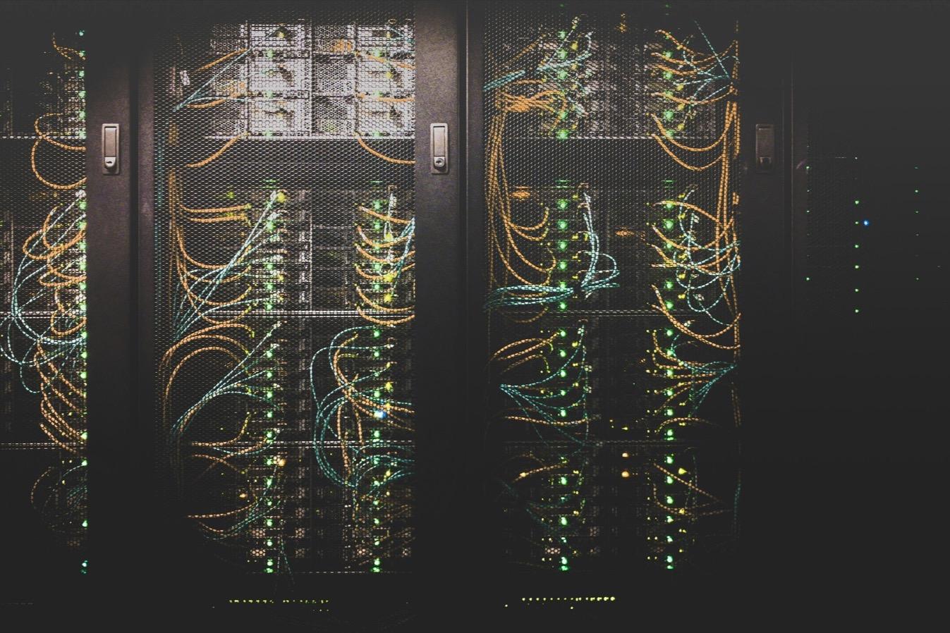 Server racks in a data hall, laced with fiber