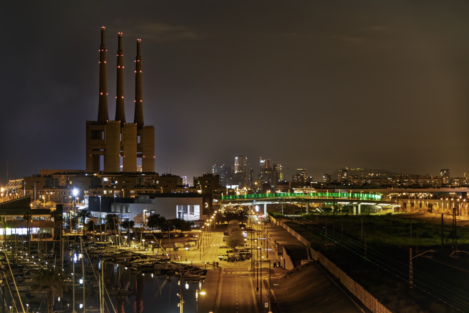 A power station lit above a marina at night, the trough that off-peak pricing is built to fill.