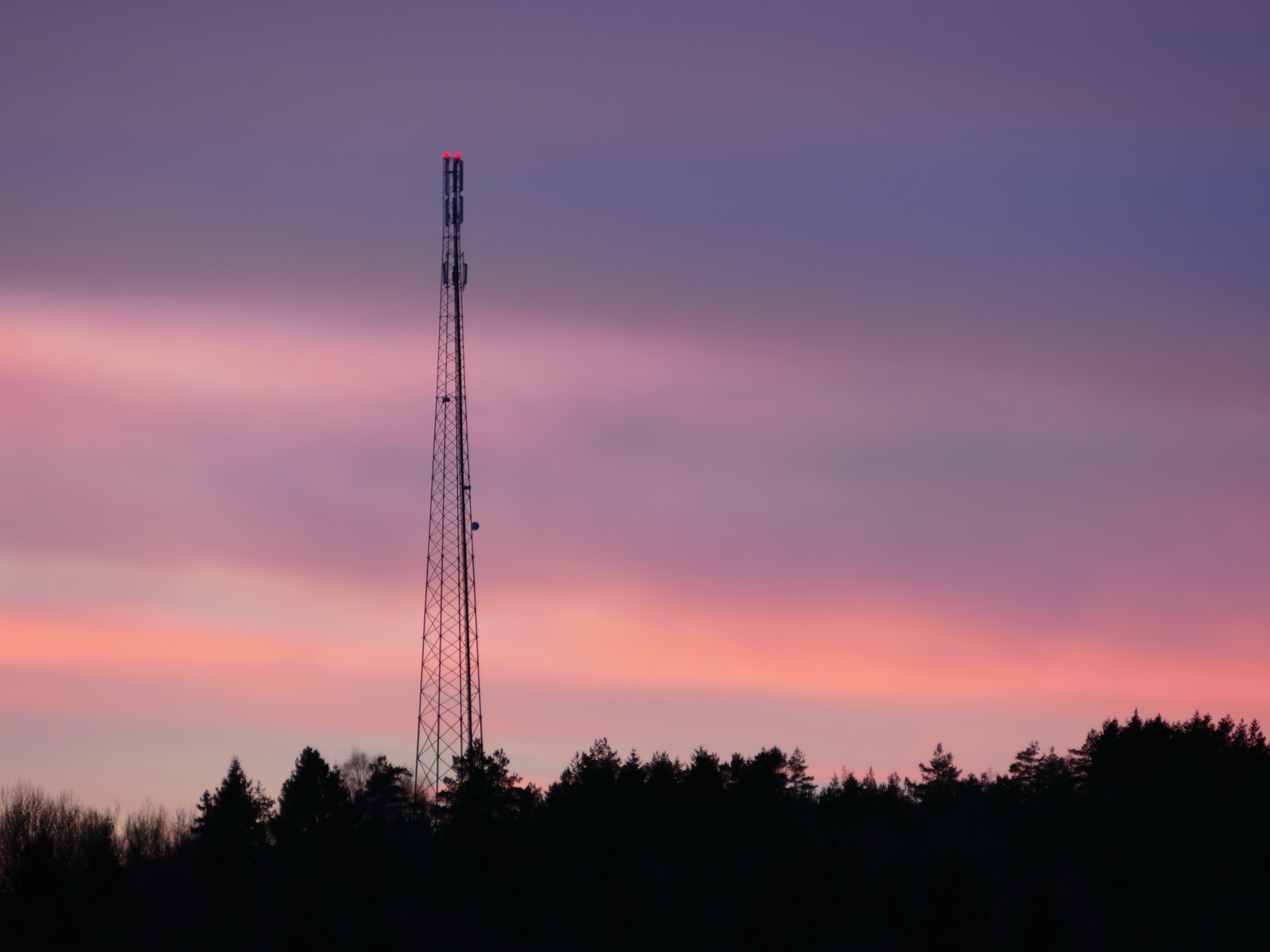 A telecommunications mast against a sunset sky, the hours when traffic falls and the radios can idle.